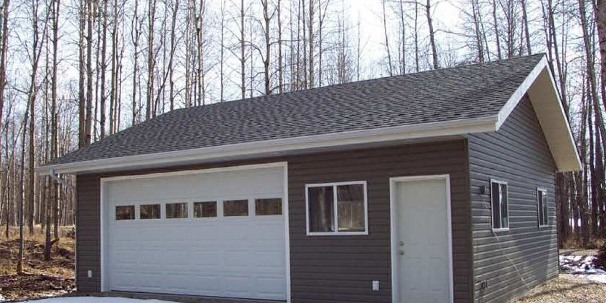 A garage sits nicely in the middle of a wooded clearing. What Is a Garage Package?