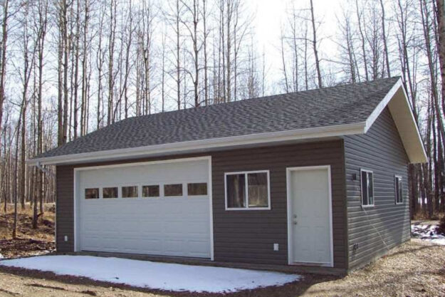 A garage sits nicely in the middle of a wooded clearing. What Is a Garage Package?